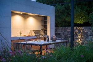 una cocina al aire libre con mesa en un jardín en Villa Kambra With Whirlpool, en Dutovlje