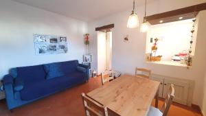 a living room with a blue couch and a wooden table at Lo Struzzo in Bagno di Romagna