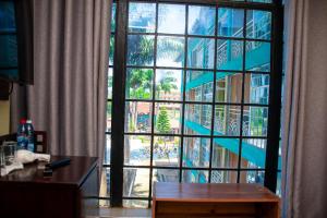 a room with a large window looking out at a city at The New Quill Hotel in Busia