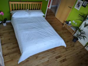Cheersome في لندن: سرير كبير في غرفة نوم مع جدار أخضر