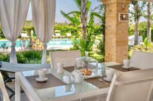 una mesa de comedor con un plato de comida. en Villa Perla Salentina luxury, en Taviano