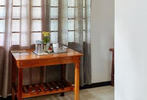 a wooden table with a flower on it next to a window at RedDoorz @ Tandikan Beach Cottages in El Nido