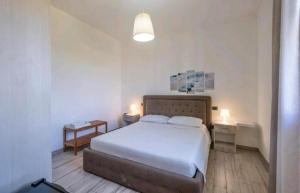 Un dormitorio con una cama blanca y dos mesas. en Villa Perla Salentina luxury, en Taviano