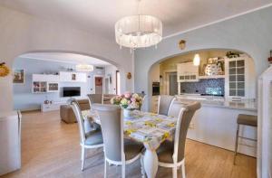Un comedor y una sala de estar con mesa y sillas. en Villa Perla Salentina luxury, en Taviano