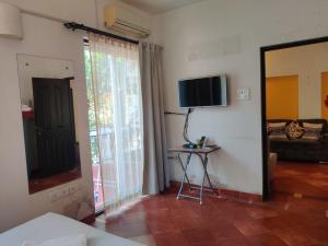 Habitación con TV y mesa. en AQUAVISTA at CasaPhilomena, en Calangute