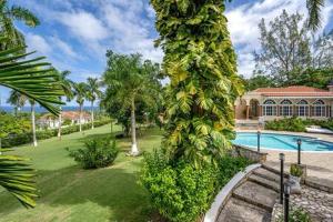 una casa con piscina y palmeras en Hospitality Expert Zeppelin - Tour Pool Bar Beach, en Montego Bay
