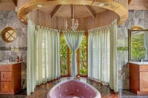 a large bathroom with a large tub and windows at Hospitality Expert Mr X Suite - Tour Pool Bar Beach in Montego Bay