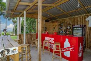 un restaurante con máquina de refrescos y mesas y sillas de madera en Hospitality Expert McCartney - Tour Pool Bar Beach en Montego Bay
