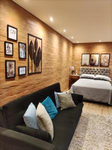 ein Schlafzimmer mit einem Bett und einem Sofa in der Unterkunft Chalé Alecrin, lançamento em conforto e estilo! in Campos do Jordão