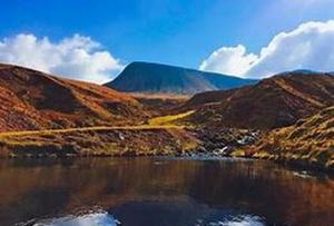 a lake in the middle of a hill with mountains at Taff Valley Cottage by StayStaycations in Merthyr Tydfil