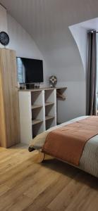 1 dormitorio con 1 cama y escritorio con TV en Entre Uzès et le Pont du Gard La Cachette Romantique en Collias