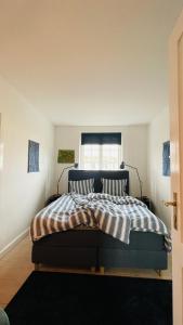 a bedroom with a bed with striped sheets and a window at ApartmentInCopenhagen Apartment 1589 in Copenhagen