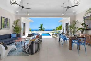 a living room with a couch and a table at Hospitality Expert Eden 7BR Pools Beach in Montego Bay