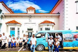 a group of people standing in front of a bus at Hospitality Expert Eden 7BR Pools Beach in Montego Bay
