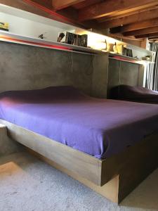 Bett in einem Zimmer mit einer lila Matratze in der Unterkunft vakantiehuis Veerse Meer met grote privétuin in Kamperland