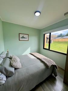 ein Schlafzimmer mit einem Bett und einem großen Fenster in der Unterkunft Refugio del Pescador in Esquel