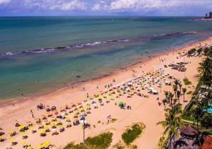 una vista panoramica su una spiaggia con persone e ombrelloni di Praia de Piedade flat frente para o mar, completo a Recife