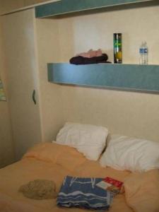een bed in een kamer met een plank erboven bij Chalet 4 étoiles - Parc aquatique - eeeahd in Canet-de-Salars