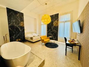 ein Bad mit einer Badewanne und ein Schlafzimmer in der Unterkunft Palazzo Otello 1847 Wellness & Spa in Vicenza