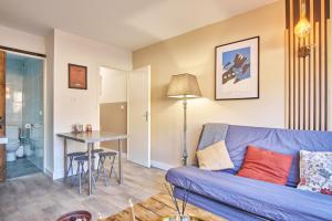 uma sala de estar com um sofá azul e uma mesa em Studio pied des pistes - Villard em Villard-de-Lans