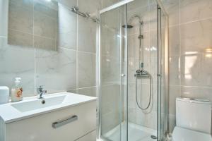 uma casa de banho com um chuveiro, um lavatório e um WC. em Studio pied des pistes - Villard em Villard-de-Lans