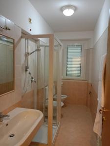 bagno con doccia, lavandino e servizi igienici di Da Enza - Appartamento al mare a Grottammare