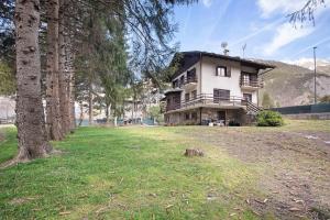 una casa grande en un campo con árboles en Maison La Truite, en Morgex