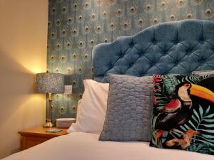 a bedroom with a bed with a blue headboard at The Briarfields in Torquay
