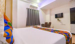 1 dormitorio con cama blanca y ventana en FabExpress The Dream Elite, en Hyderabad