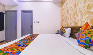1 dormitorio con 1 cama grande con una manta colorida en FabExpress The Dream Elite, en Hyderabad