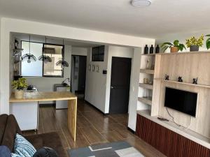 a kitchen and living room with a table and a television at Hermoso apartamento ibagué 202 F2 in Ibagué