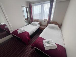 a small room with two beds and a window at Brig Inn Hotel in Aberdeen