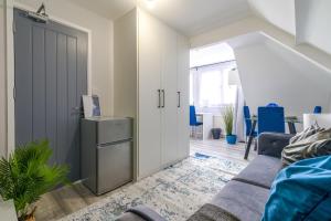 uma sala de estar com um sofá e uma porta em 12 Elmwood em Harrow