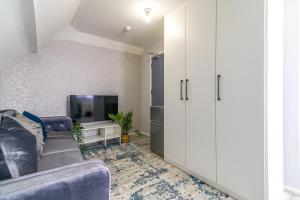 a living room with a couch and a tv at 12 Elmwood in Harrow