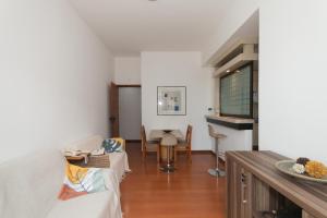 een woonkamer met een bank en een tafel bij Apartamento savassi - comodidade e localização in Belo Horizonte