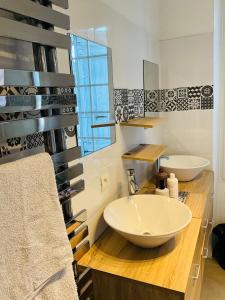 ein Badezimmer mit einem großen weißen Waschbecken und einem Spiegel in der Unterkunft No 14 , 15 meters plein centre Mirepoix apartment Très Calme Netflix ,Terrace Sleeps 4 70 m2 in Mirepoix