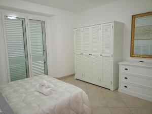 a bedroom with a white bed and a dresser at Da Enza - Appartamento al mare in Grottammare