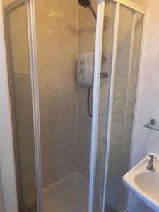 uma casa de banho com um chuveiro e um lavatório. em Brig Inn Hotel em Aberdeen