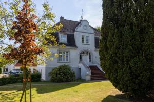 a white house with a black roof at Villa Friedericia, Wohnung 3-Hochparterre links in Wyk auf Föhr