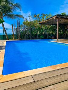 a large blue swimming pool with a gazebo at Pousada Vila das Velas in Ilhabela