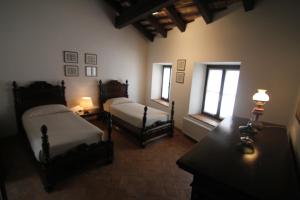 Togliano的住宿－Volpe Pasini - Wine and Rooms，一间卧室设有两张床和两个窗户。