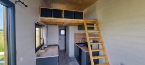 a tiny house with a kitchen and a ladder at Tiny house cosy proche Disney in Bannost