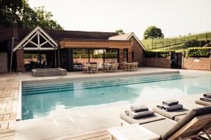 a swimming pool with chaise lounges and a patio at Talbooth House & Spa in Dedham