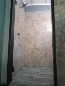 La salle de bains est pourvue d'un mur en pierre et d'une douche. dans l'établissement Dam House Lodge, à Hartbeespoort