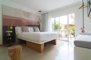 a bedroom with a white bed and a balcony at Boutique Apartments Marsol Ibiza in Santa Eularia des Riu