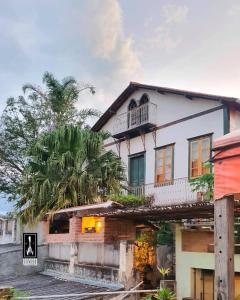 a house with a palm tree in front of it at Hostel Pousada Harpia in Passa Quatro