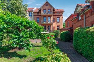 ポツダムにあるGründerzeitvilla in Potsdamのレンガ造りの大きな建物で、正面に庭園があります。