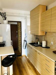 a kitchen with wooden cabinets and a counter top at Cristal Apartament Krynica - Zdrój in Krynica Zdrój