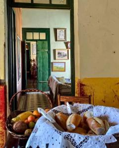 a basket of bread and fruit on a table at Hostel Pousada Harpia in Passa Quatro