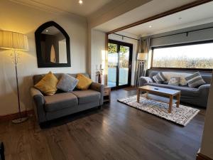 a living room with a couch and a table at Detached 3 Bed Cottage Mountain Views- Pets Wifi in Beaumaris